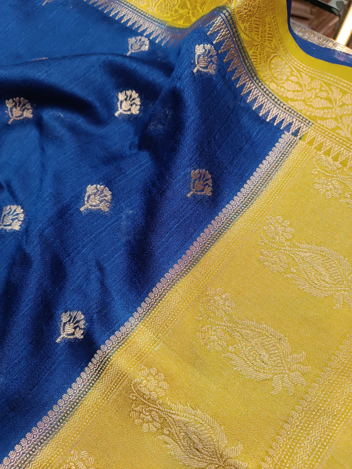 Close-up of a blue and yellow fabric with intricate patterns