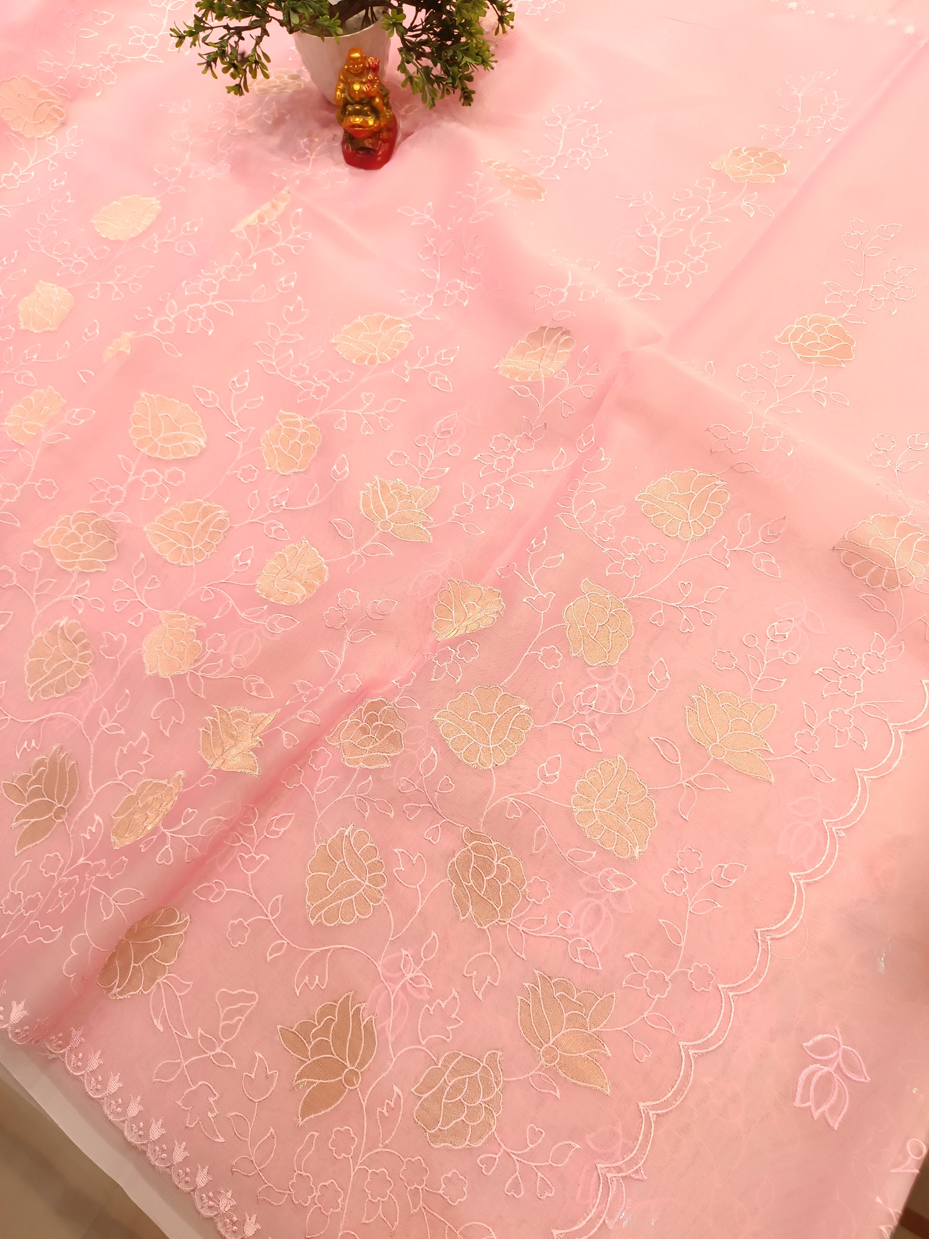 Pink fabric with gold leaf pattern on a table
