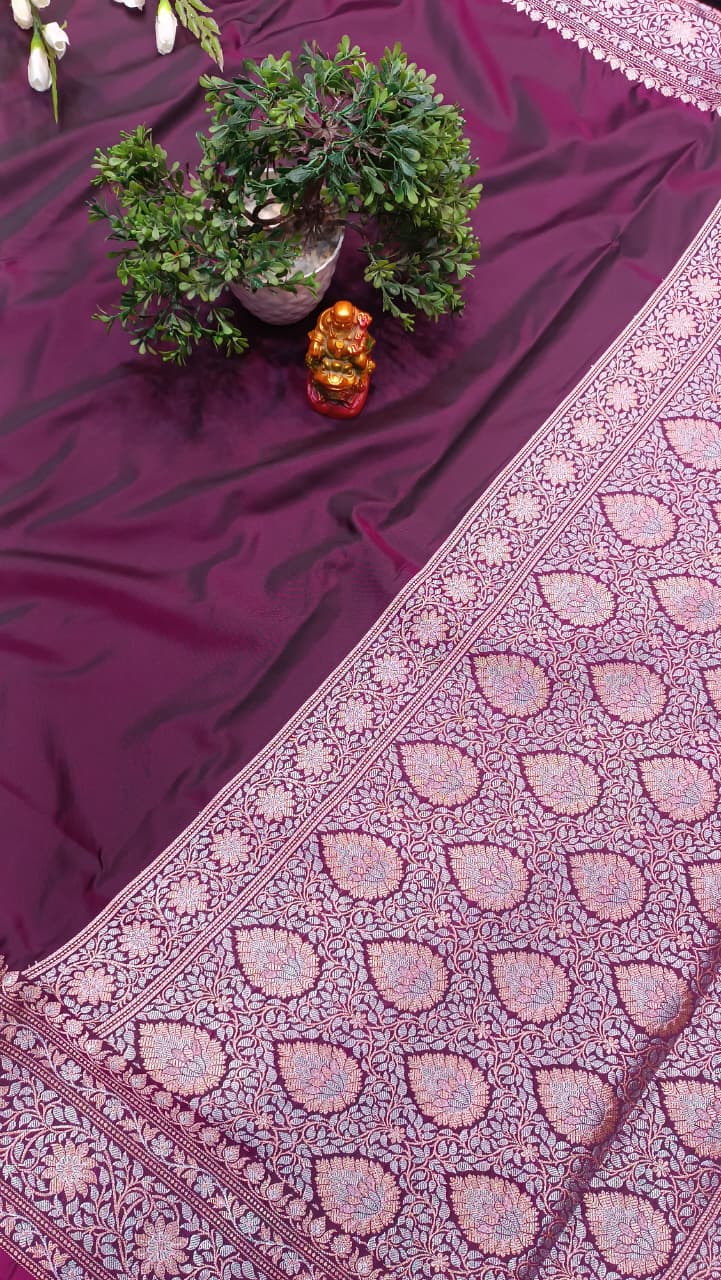 Purple fabric with intricate patterns and a plant on a dark background