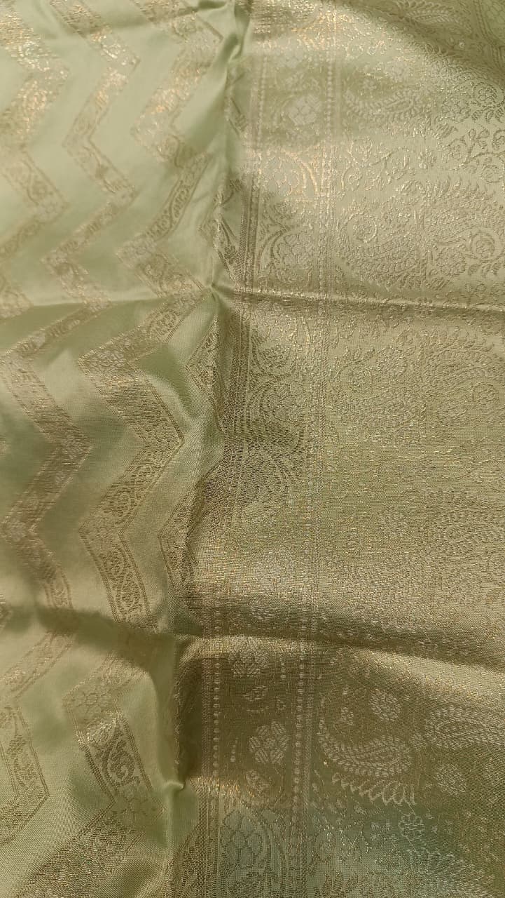 Green fabric with intricate patterns and embroidery