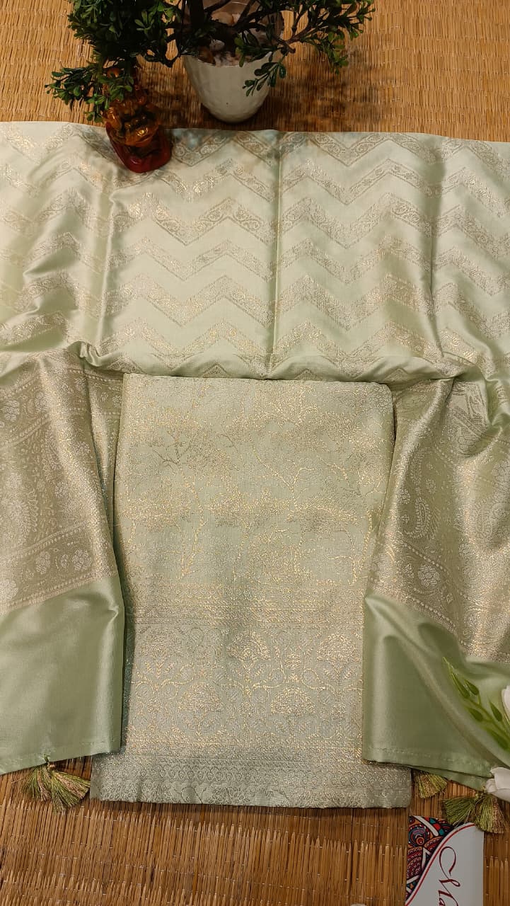 Light green fabric with intricate patterns on a wooden surface